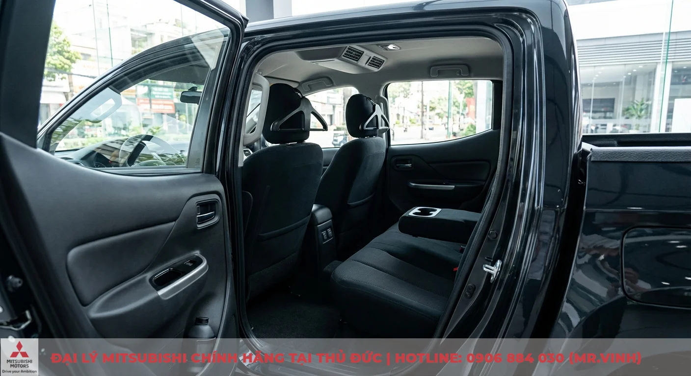 Nội thất Triton 2026: Đánh giá chi tiết thiết kế, công nghệ & tiện nghi 3 Khoang nội thất xe bán tải màu đen với cửa gió điều hòa sau, hàng ghế thứ hai có bệ tỳ tay kiêm hộc đựng cốc và móc treo đồ